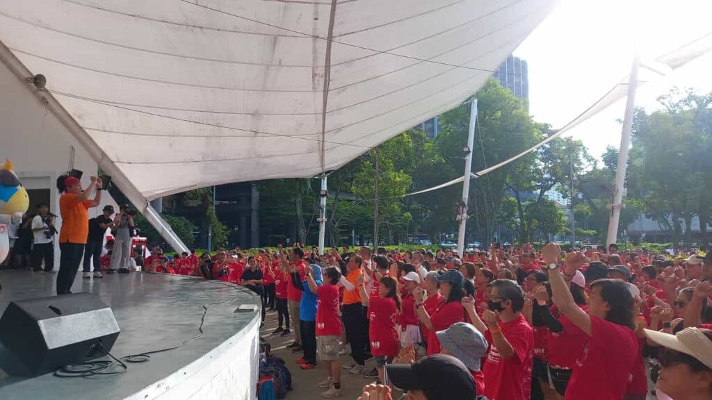 A peace prosperity event attended by people in red shirts. The event is secured by event security companies